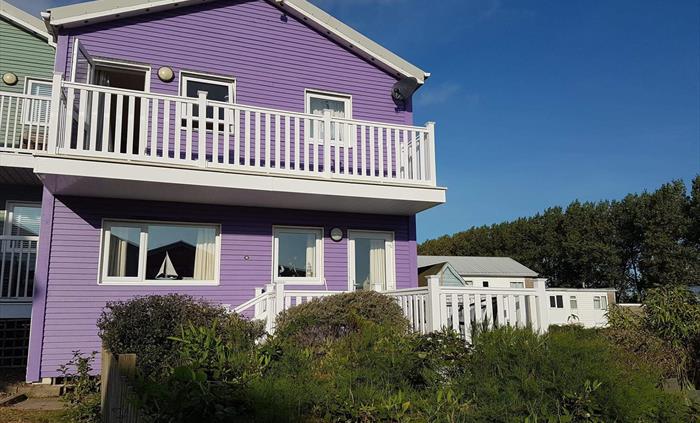 The front of the house, showing its two decks to enjoy the sun or the wind! The bottom deck has been extended.